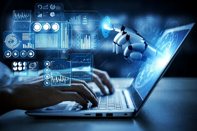 Eine Bildkomposition aus menschlichen Händen, die auf einem Laptop tippen, und einer Roboterhand, die aus dem Bildschirm herausgreift.